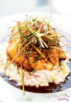 <p>A heavenly parmesan crust pays tribute to snapper lying on a bed of ham and pineapple infused risotto and a pool of port wine reduction. Opposite page: The pimento cheese cake appetizer.</p>