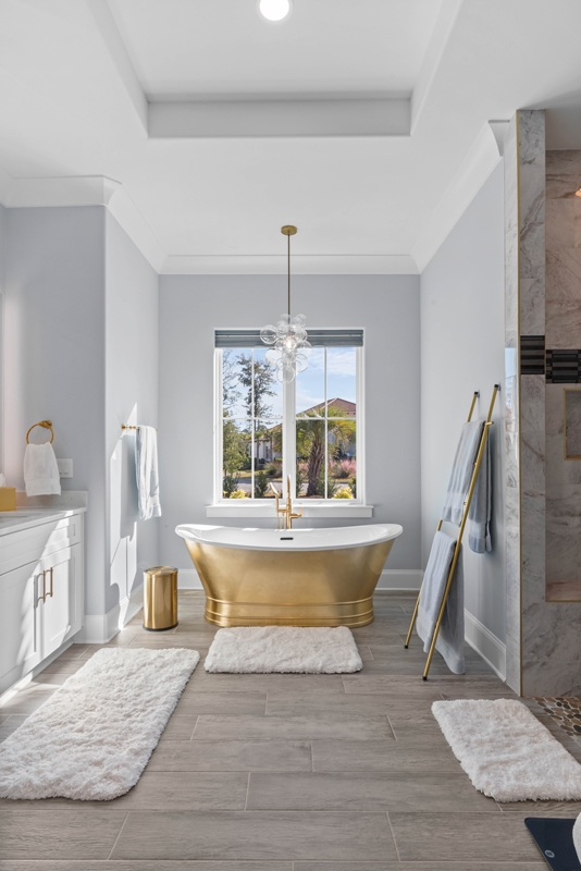 This heavenly primary bathroom shines, with ethereal lighting and a centerpiece gold-plated soaking tub.