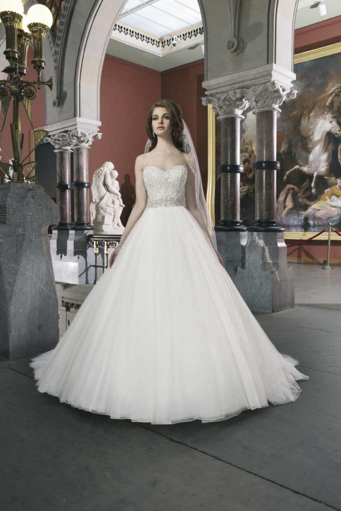 JUSTIN ALEXANDER: This tulle ballgown features an intricately beaded bodice with a sweetheart neckline and regal satin buttons down the zipper. Style 8724. The Little White Dress, $1,658