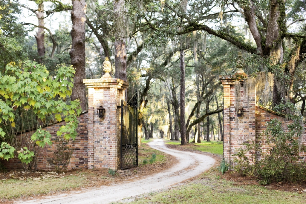 The long and winding road to Estherville Plantation starts at these lighted brick pillars supporting pineapple finials, the Sout