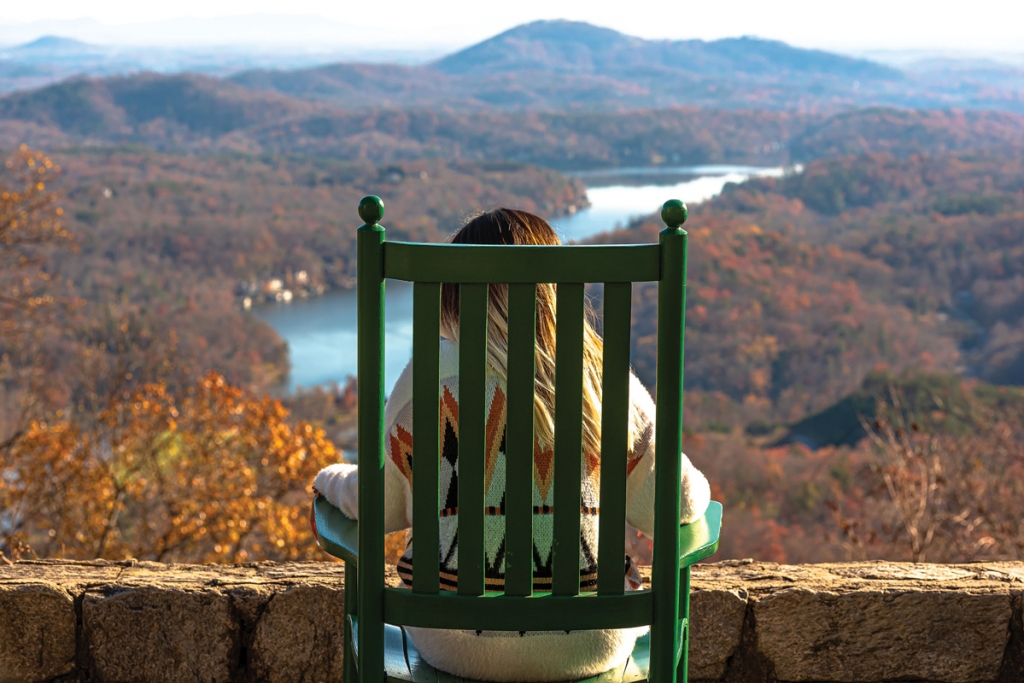 At left, visitor contemplates the serene beauty of Lake Lure from atop Chimney Rock.