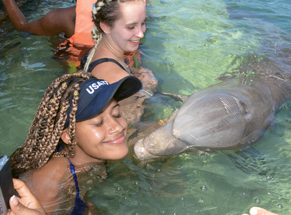 Kaylin West gets kissed by a dolphin