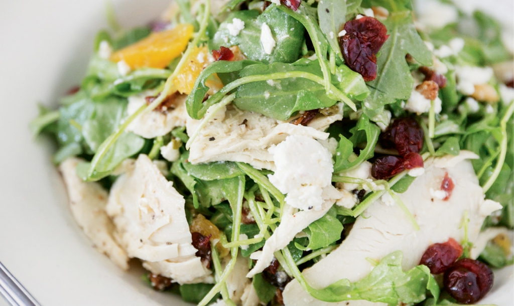 The Grilled Chicken Arugula Salad gets sweetened up with tangy dried cranberries, pecans and orange wedges.