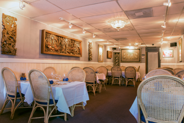 The cozy dining room at Blue Elephant is a white linen affair with beautiful dishware.