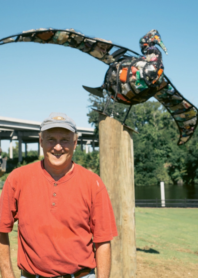 Jim Swaim, pictured here with his Environmental Sculptures artwork that also serve as trash containers.