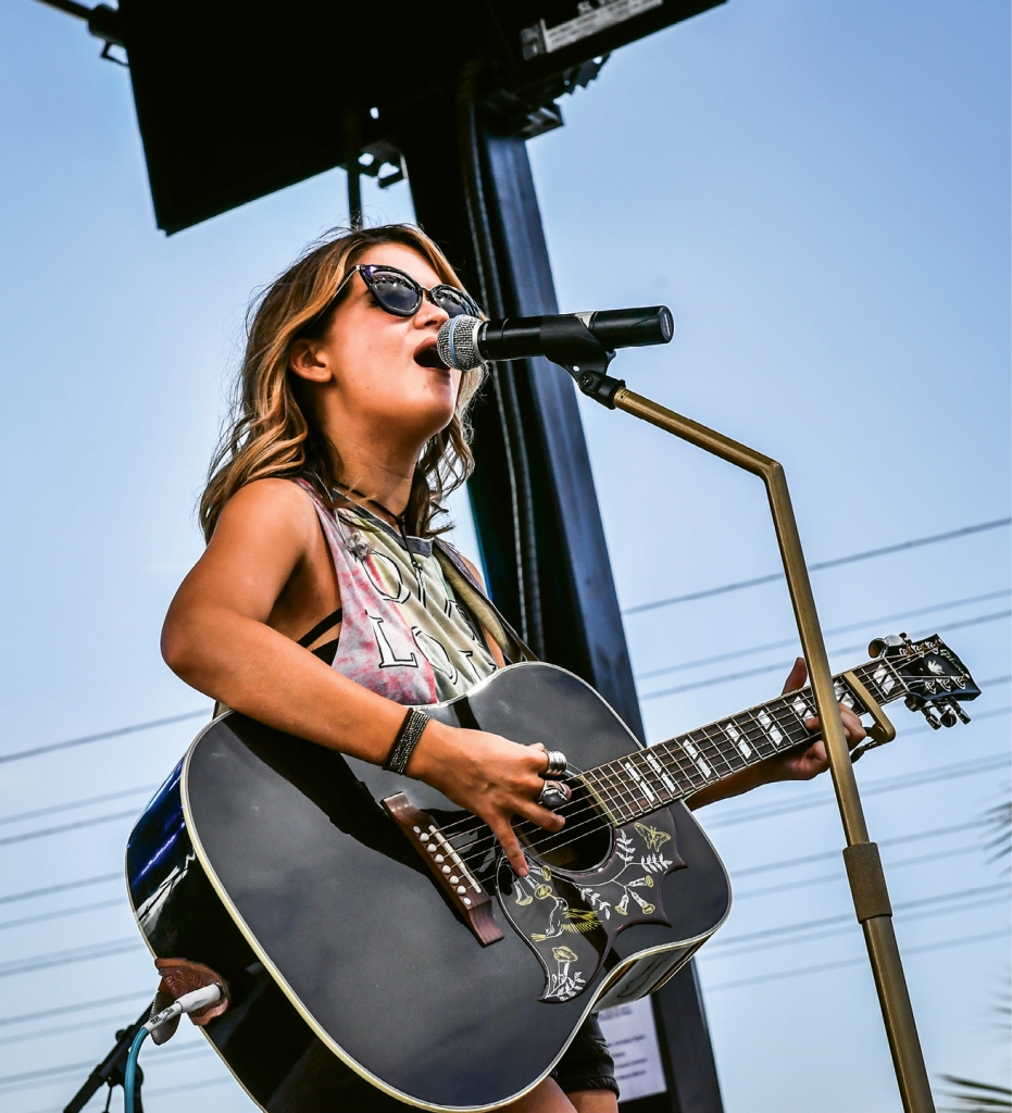 Maren Morris performs in 2016 with a sunny ocean backdrop.