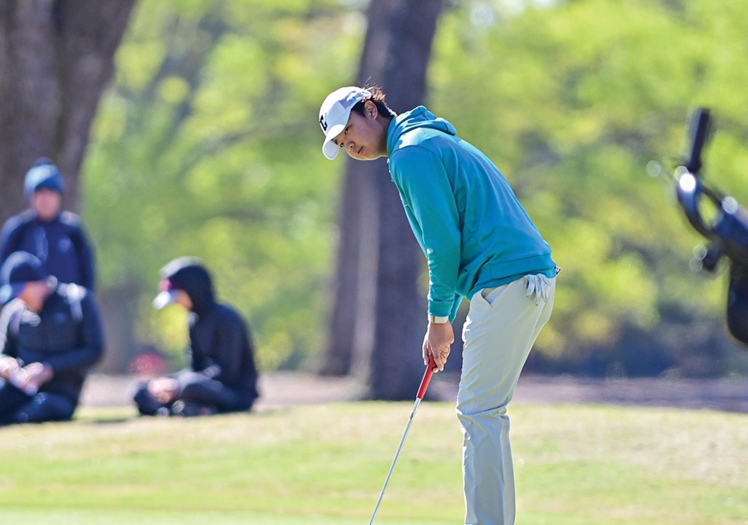 Owen Kim tracks his putt on a chilly afternoon.