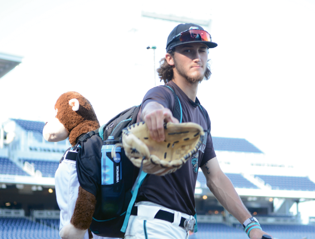 Scenes from the 2016 College World Series: Bobby Holmes takes the field with Rafiki in tow.
