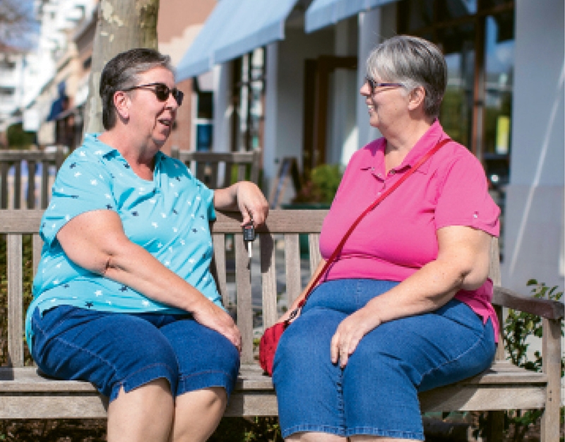 Carol Hannon (left) and her sister, Vivian, talk outside of their Market Common apartment.