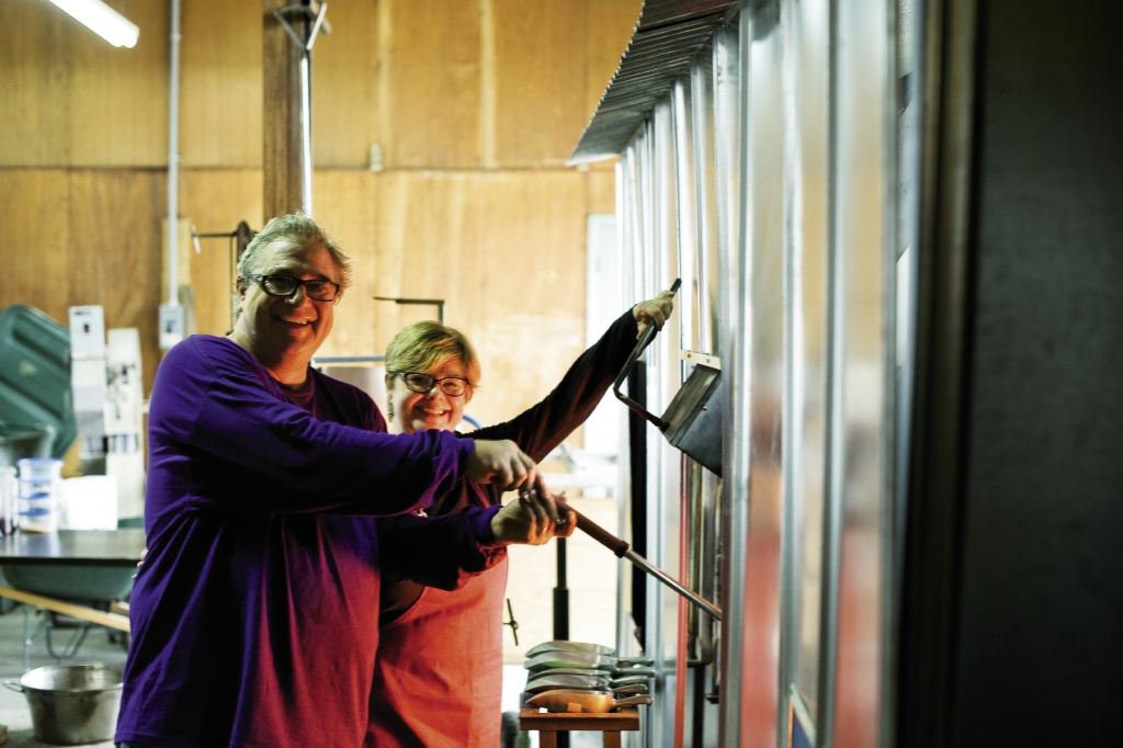 Barbara and Ed Streeter, the “hot shop team,” prepare to remove glass from the oven.